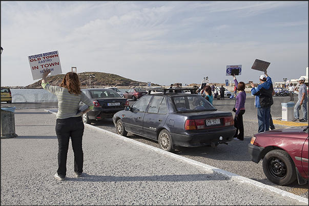 Port of Naxos, tourists are greeted by signs to rent rooms and B&B