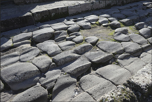 Stones worn down by the passage of people, animals and carts that have left deep ruts on the road