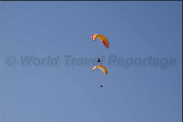 Paraglider flying over the lake